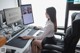 A woman sitting at a desk using a computer.