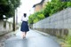 A woman walking down a street holding an umbrella.