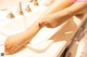 A woman's feet sitting on a bathroom sink.