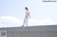 A woman in a kimono standing on a concrete wall.