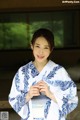 A woman in a blue and white kimono posing for a picture.